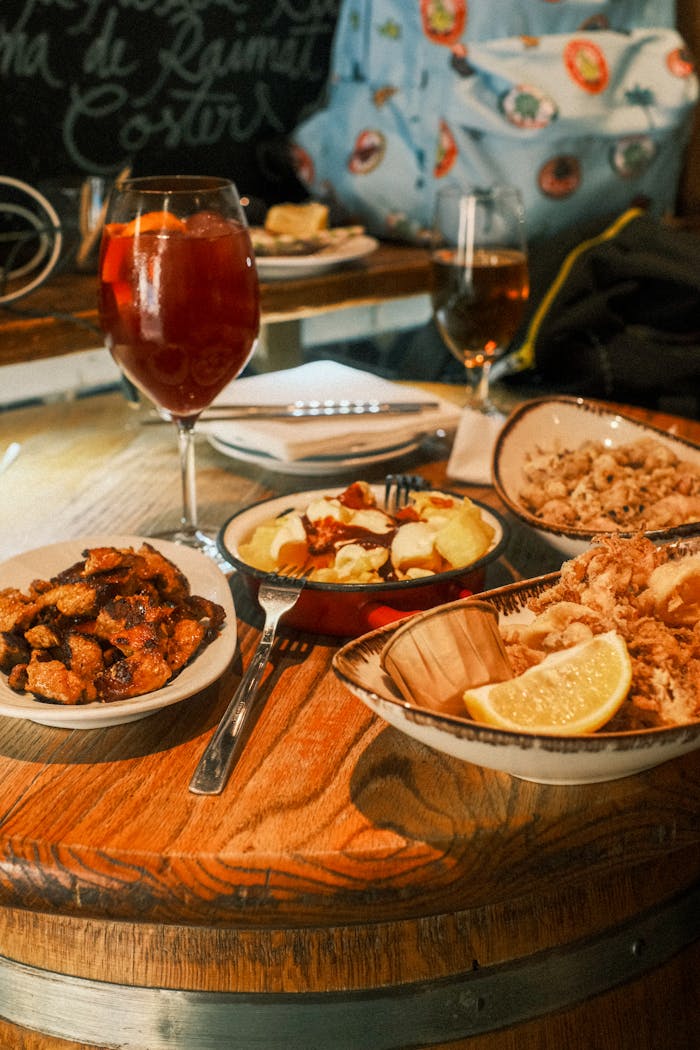 who-we-are A table set with a variety of Spanish tapas and a glass of sangria in a cozy Barcelona restaurant.
