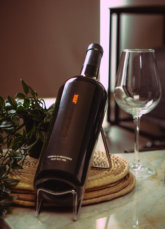 pexels photo 29264102 Elegant wine bottle and glass with greenery on a table.