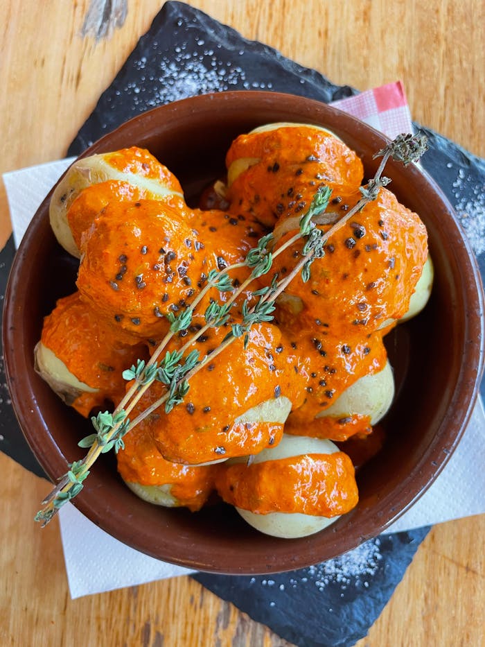 journey Traditional Canarian papas arrugadas topped with spicy red mojo sauce, a savory delight.